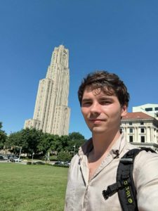 Mgr Michał Wieczorkowski na tle wieżowca w Pittsburghu